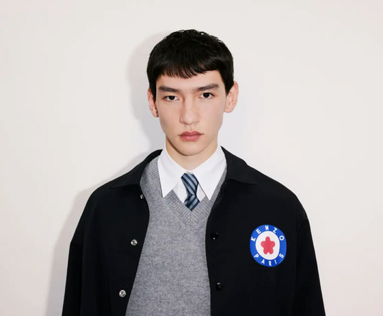 A young man wearing a school uniform with a Kenzo jacket