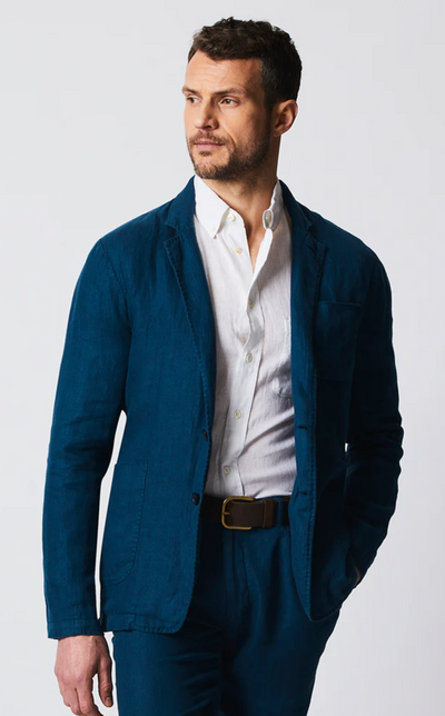 A man wearing a Billy Reid navy blue suit and white button up shirt