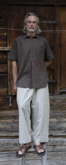 A man wearing a Frank Leder brown button up t-shirt and white loose pants