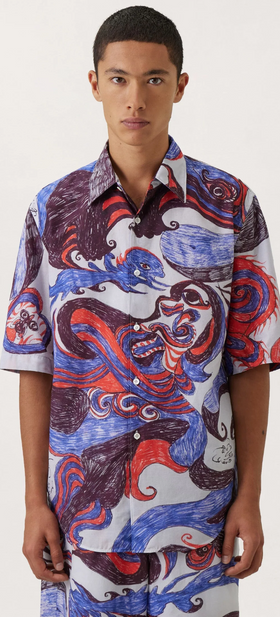 A man wearing a Lemaire dragon print button up with matching shorts
