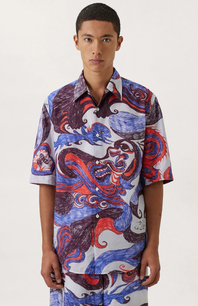 A man wearing a Lemaire dragon print button up with matching shorts