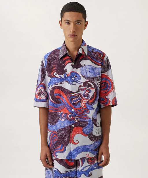 A man wearing a Lemaire dragon print button up with matching shorts
