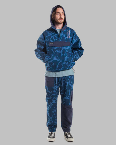 A man wearing a camo print Publish Brand hoodie and sweats