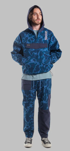 A man wearing a camo print Publish Brand hoodie and sweats