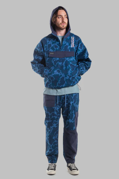 A man wearing a camo print Publish Brand hoodie and sweats