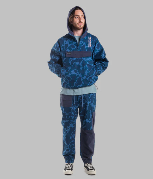 A man wearing a camo print Publish Brand hoodie and sweats