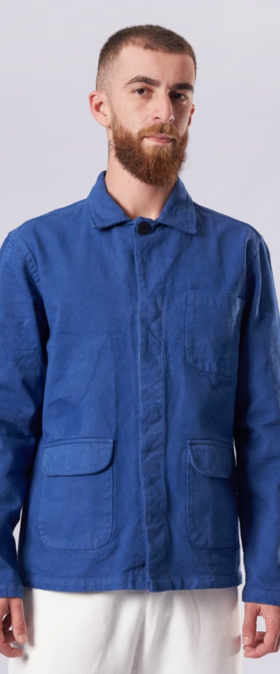 A man wearing a La Paz denim shirt with white pants