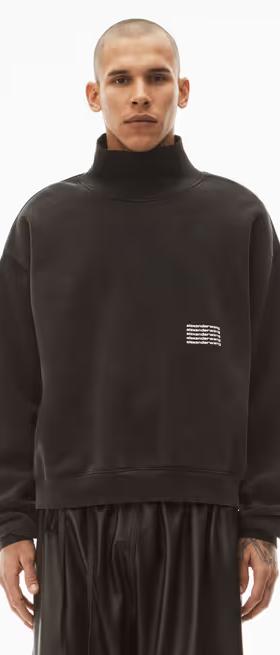 A man wearing an Alexander Wang logo fleece with black pants