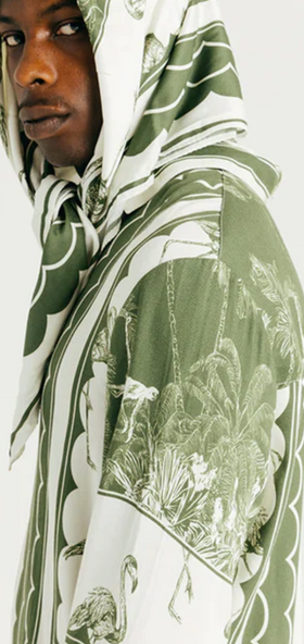 A man wearing a Ih Nom Uh Nit hoodie in green bandana