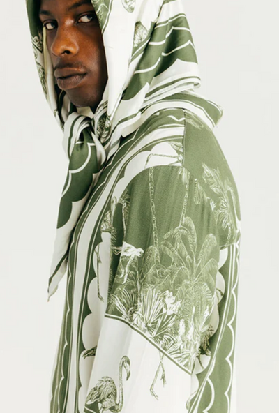 A man wearing a Ih Nom Uh Nit hoodie in green bandana