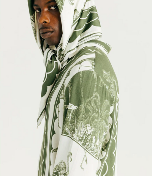 A man wearing a Ih Nom Uh Nit hoodie in green bandana