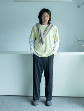 A man wearing a Lady White Co t-shirt and pants with a sweater draped over