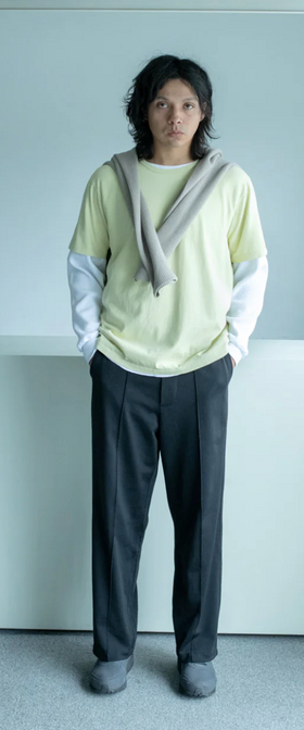 A man wearing a Lady White Co t-shirt and pants with a sweater draped over