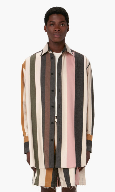 A man wearing a striped J.W. Anderson button up with matching shorts