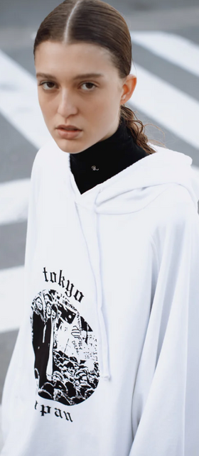 A woman wearing a Raf Simons Tokyo white hoodie