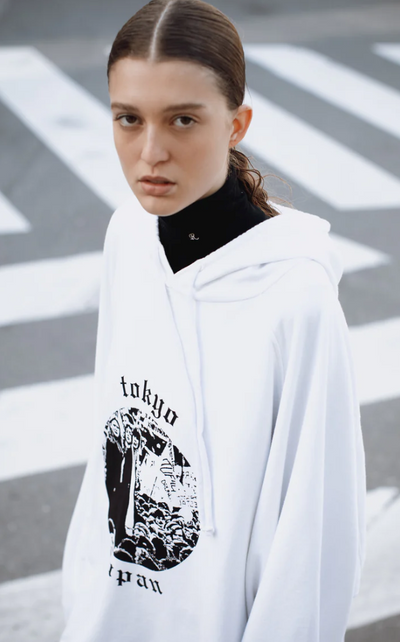 A woman wearing a Raf Simons Tokyo white hoodie