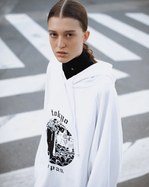 A woman wearing a Raf Simons Tokyo white hoodie