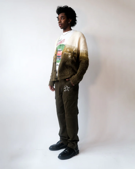 A man wearing a Jehucal cardigan a white print t-shirt