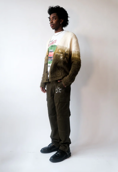 A man wearing a Jehucal cardigan a white print t-shirt