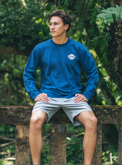A man wearing a Hurley long-sleeve blue short and board shorts