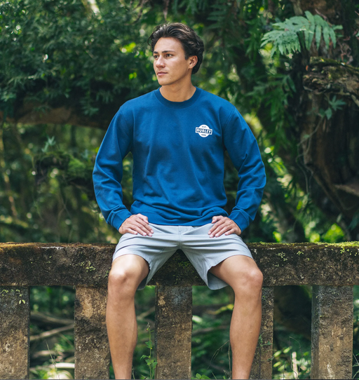 A man wearing a Hurley long-sleeve blue short and board shorts