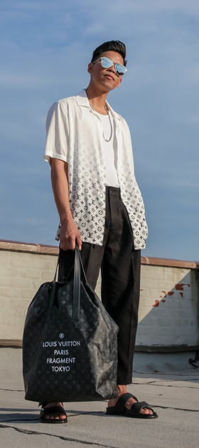 A man wearing a Fragment x Louis Vutton button up and black pants
