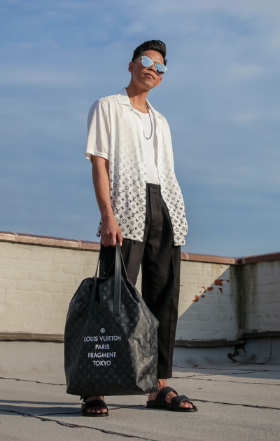 A man wearing a Fragment x Louis Vutton button up and black pants