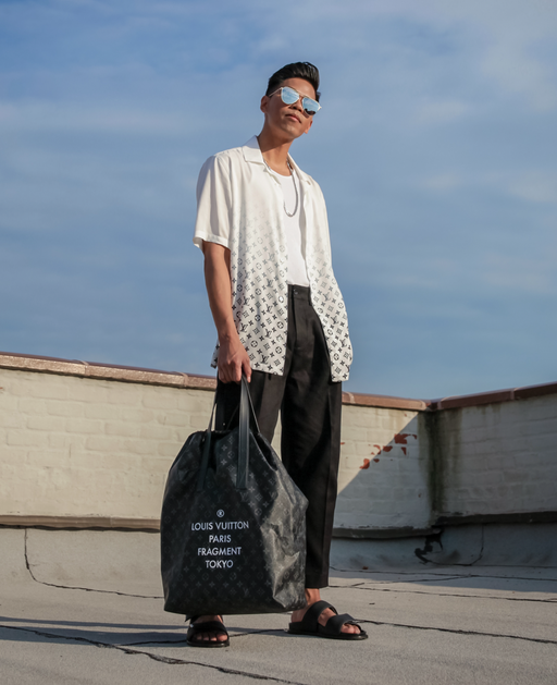 A man wearing a Fragment x Louis Vutton button up and black pants