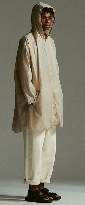 A man wearing an Element outfit with a long beige raincoat and beige pants