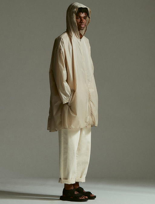 A man wearing an Element outfit with a long beige raincoat and beige pants