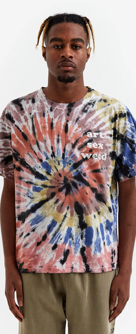 A man wearing a tie dye Goodhood t-shirt and green pants