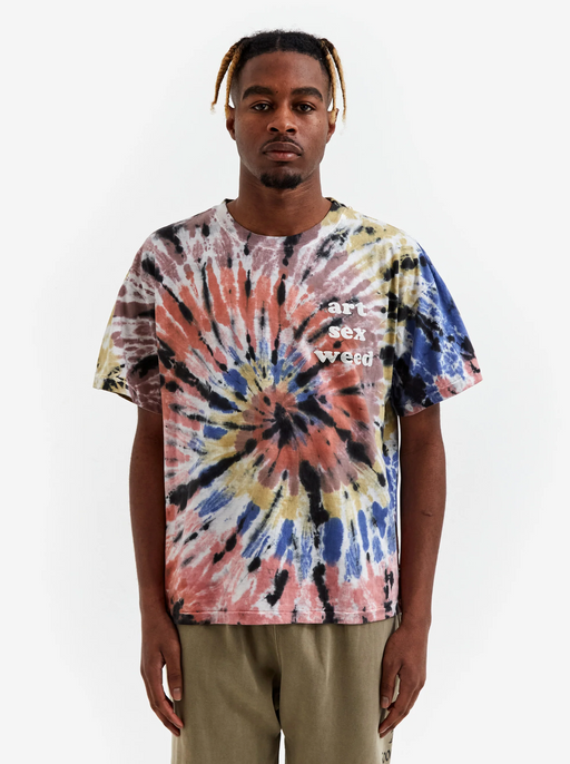 A man wearing a tie dye Goodhood t-shirt and green pants