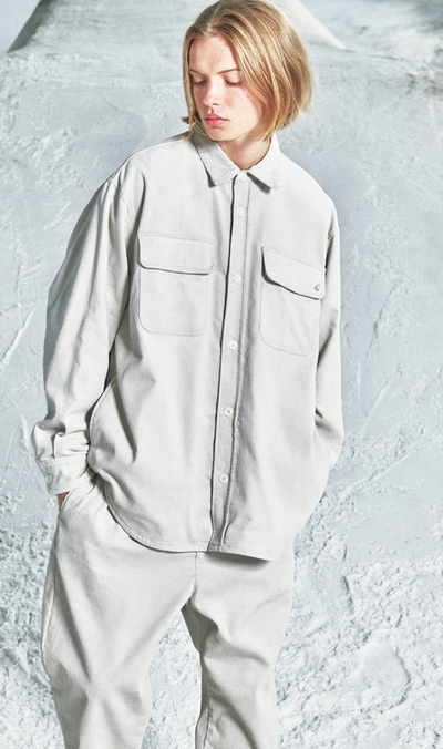 A woman wearing a space grey SOPHNET. button up and matching pants