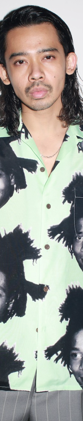 A man wearing a Wacko Maria Jean-Michel Basquiat all over print button up t-shirt