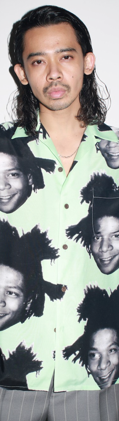 A man wearing a Wacko Maria Jean-Michel Basquiat all over print button up t-shirt
