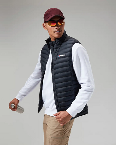A man wearing a Berghaus vest, long-sleeve and a red hat