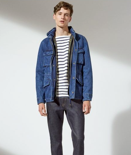 A man wearing a denim GAP jacket along with a striped shirt and denim