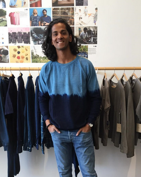 A man wearing a blue Industry of All Nations long-sleeve in the store