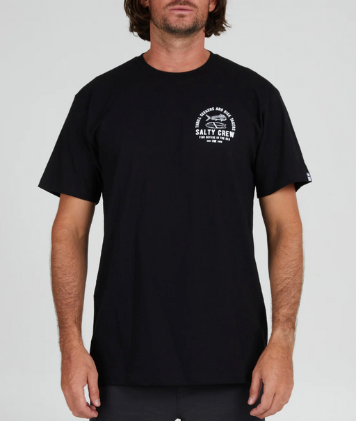 A man wearing a Salty Crew black t-shirt with a white logo on the chest