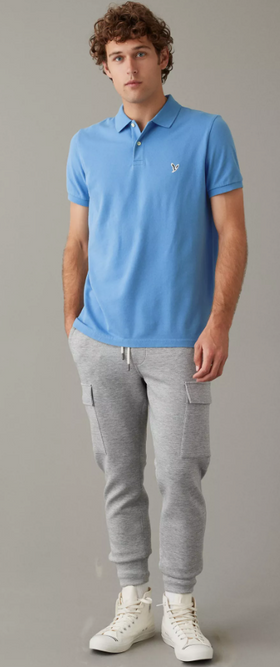 A man wearing a blue American Eagles Outfitters collared shirt with grey sweats