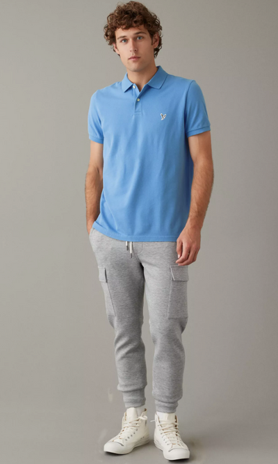A man wearing a blue American Eagles Outfitters collared shirt with grey sweats