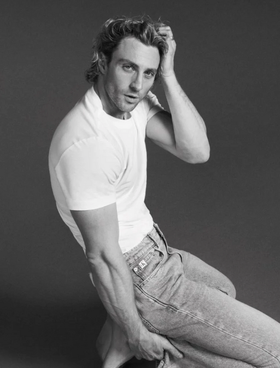 A man wearing a Calvin Klein white t-shirt and jeans