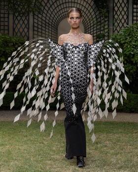 A woman wearing a floral extravagant dress by Iris Van Herpen
