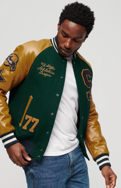 A man wearing a Superdry Varsity Jacket in green and brown