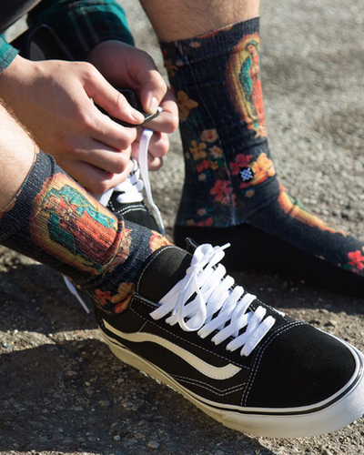 A man wearing a Mother Mary Stance socks and Vans shoes