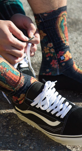 A man wearing a Mother Mary Stance socks and Vans shoes
