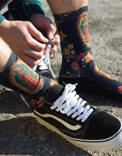 A man wearing a Mother Mary Stance socks and Vans shoes