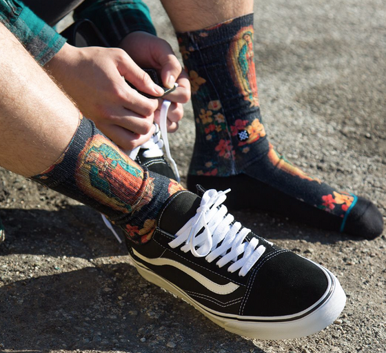 A man wearing a Mother Mary Stance socks and Vans shoes