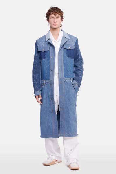 A man wearing a denim overcoat by Marine Serre and white pants and button ups