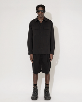 A man wearing a Han Kjøbenhavn black shirt and shorts